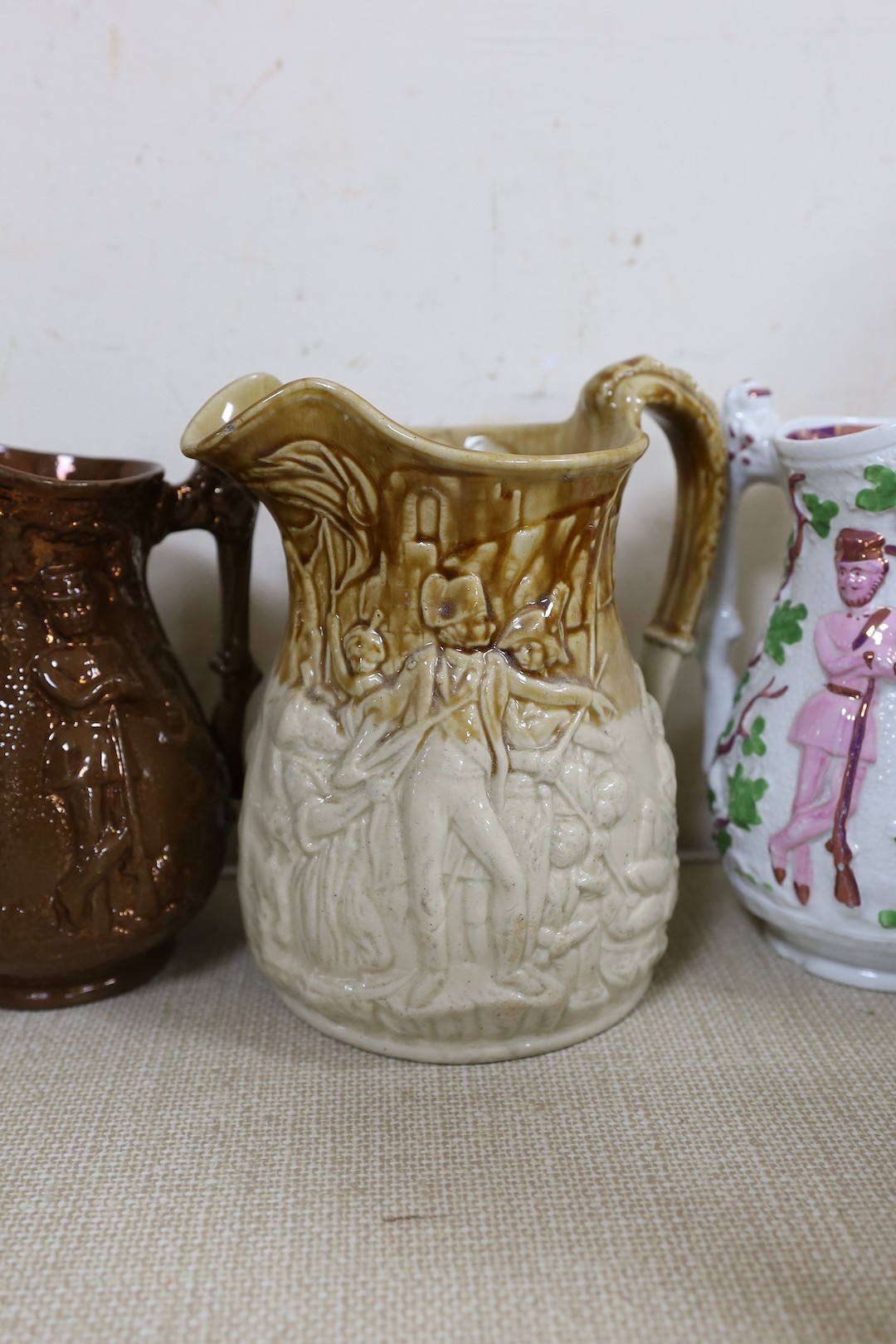 A Doulton Lambeth South Africa 1900 commemorative jug, 21cm, two relief moulded Volunteer jugs and four other jugs